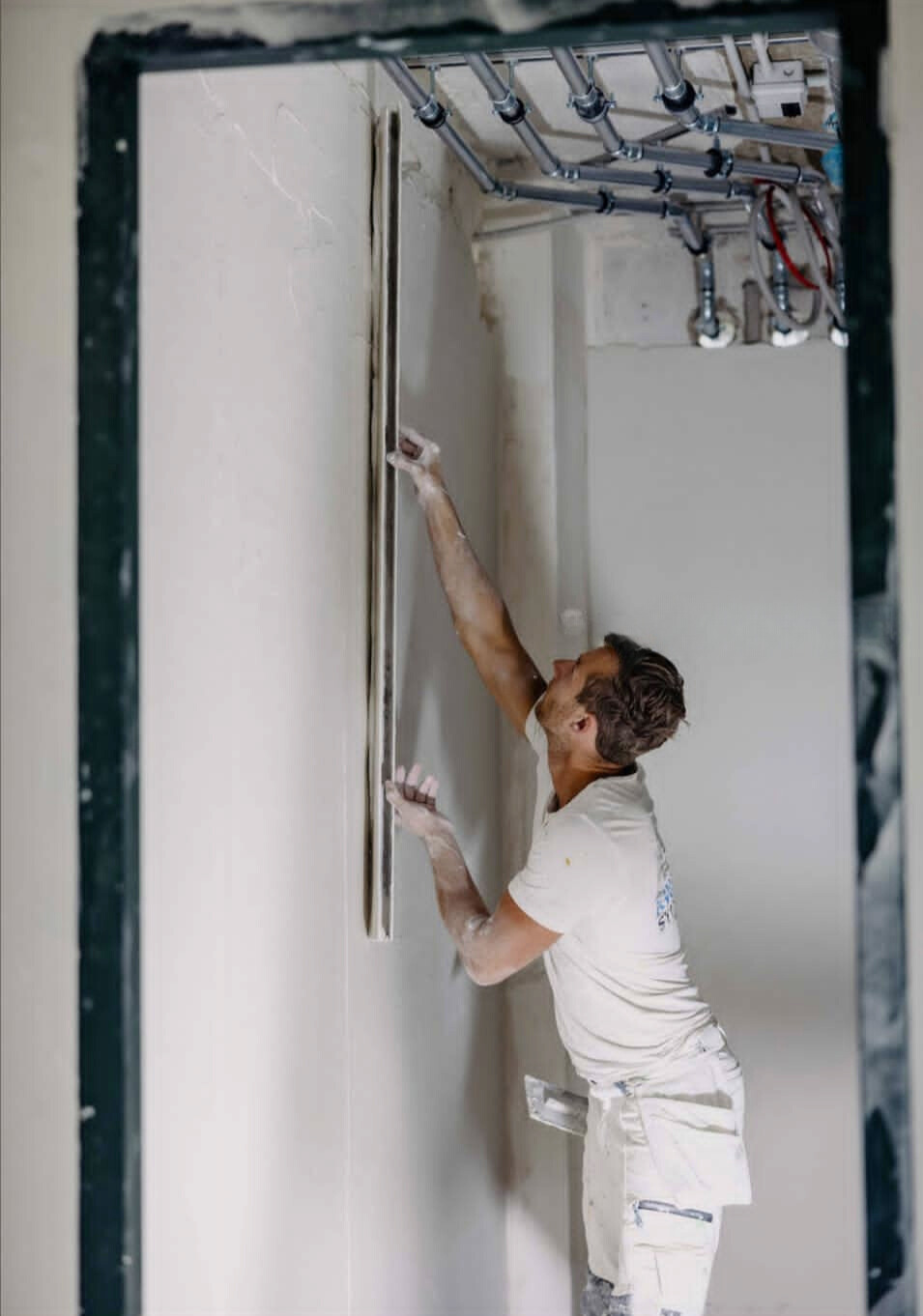 Trium Afbouw stucadoor werkt sierpleister aan een binnenmuur