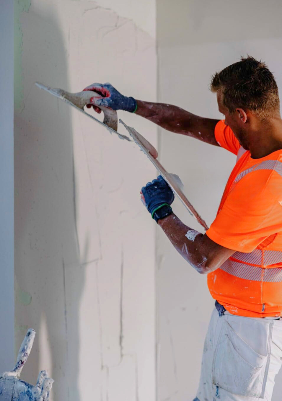 Stucadoor van Trium Afbouw aan het werk met pleisterspaan